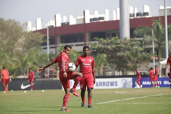 Churchill Brothers&#039; players warm up before the I-League match against Indian Arrows at the practice pitch of the Kalinga Stadium. The main ground is visible in the background (Image: AIFF Media)