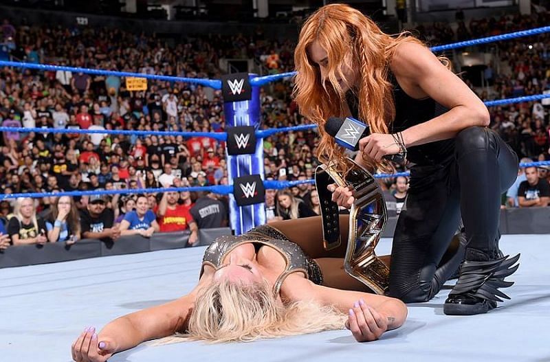 Becky Lynch is shown kneeling over her former friend but now bitter enemy, Charlotte Flair.
