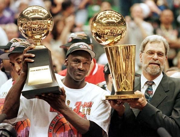Jordan with his sixth NBA Finals MVP trophy alongside Bulls&#039; coach Phil Jackson