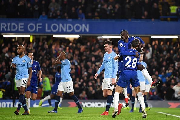 Dejected Manchester City players look on as Chelsea celebrate