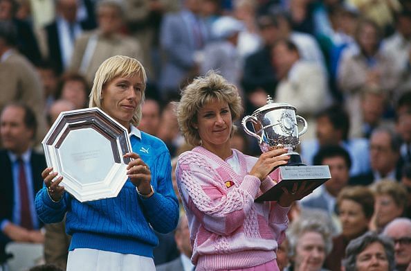 Navratilova and Evert posing with the 1986 French Open runner-up and winners trophies respectively