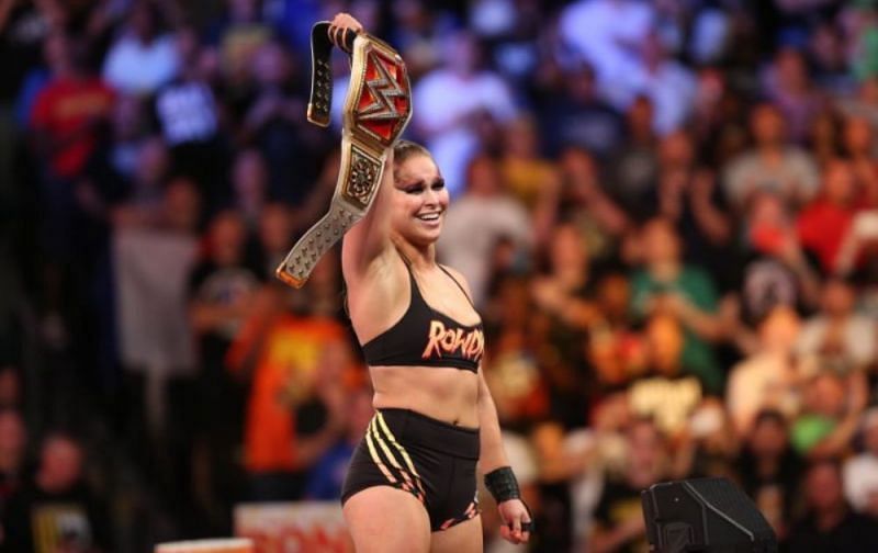 Rousey is shown celebrating after winning her first championship gold in the WWE.