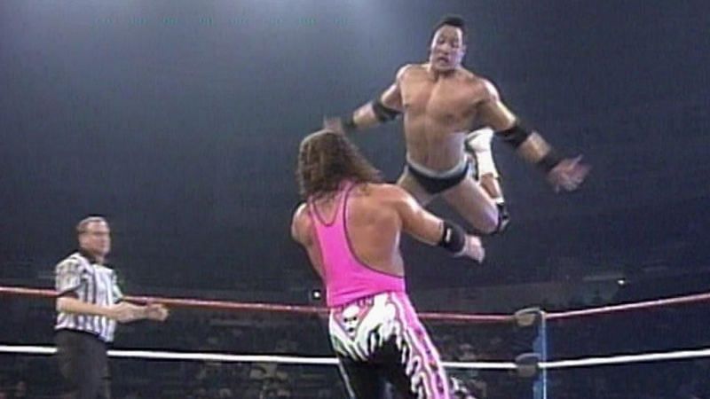 A rookie Rocky leaps from the top rope onto an irate Hitman.