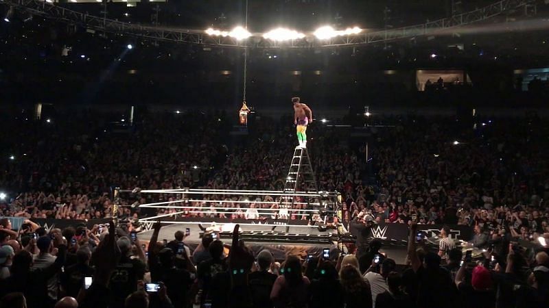 Velveteen Dream stands on the uppermost step of a monstrously tall ladder, awing the live crowd with his daring.