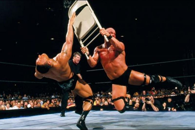 Stone Cold Steve Austin demolishes the Rock with a folding steel chair at Wrestlemania XVII