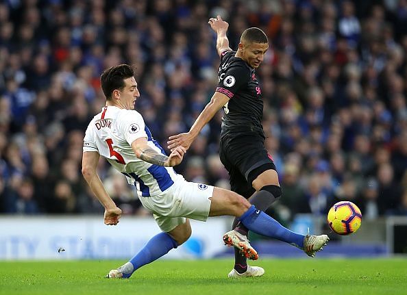 Lewis Dunk tackling Everton attacker Richarlison