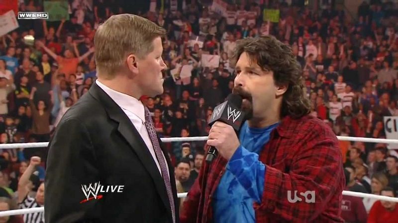 John Laurinaitis is confronted by Mick Foley in the ring.
