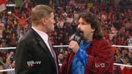 John Laurinaitis is confronted by Mick Foley in the ring.