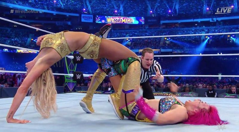 Asuka is trapped in Charlotte Flair&#039;s Figure 8 leglock.