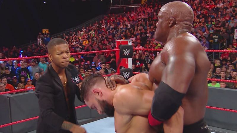 Lio Rush attacking Finn Balor, who&#039;s held by Bobby Lashley