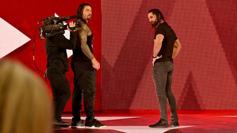 Roman Reigns and Seth Rollins looking at a fallen Dean Ambrose!