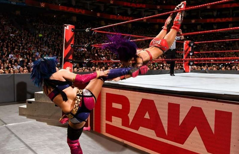 Asuka blocks a suicide dive from Banks with a kick