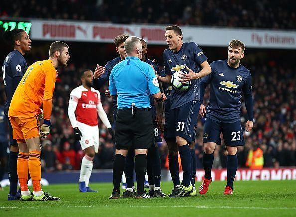 Manchester United players protesting against the penalty decision.