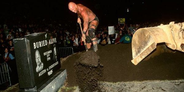 Stone Cold Steve Austin throws dirt on top of Undertaker&#039;s coffin during a 