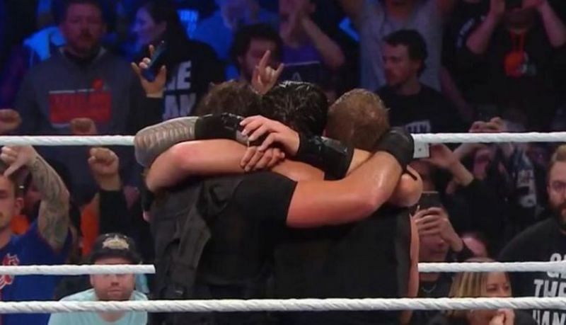 Dean Ambrose, Seth Rollins, and Roman Reigns embrace after their six-man tag victory at Fastlane.
