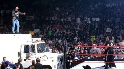 Stone Cold on top of a beer truck before spraying The Rock and The McMah