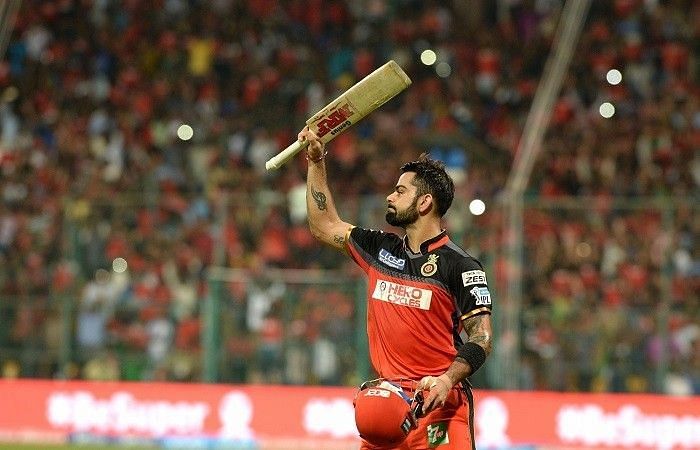 An emotional Kohli raises his bat in acknowledgment