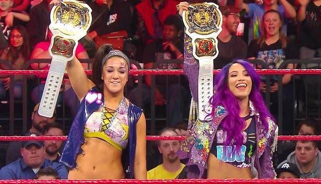 Sasha and Bayley posing with their belts