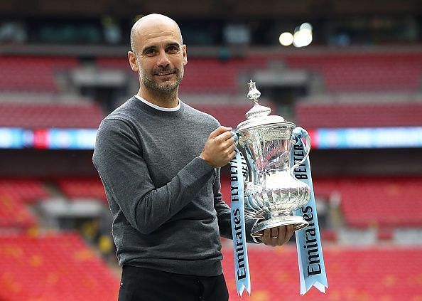 Manchester City&#039;s Pep Guardiola holds the FA Cup.