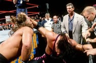 Bret Hart brawls with Shawn Michaels as Vince McMahon looks on at the 1997 Survivor Series