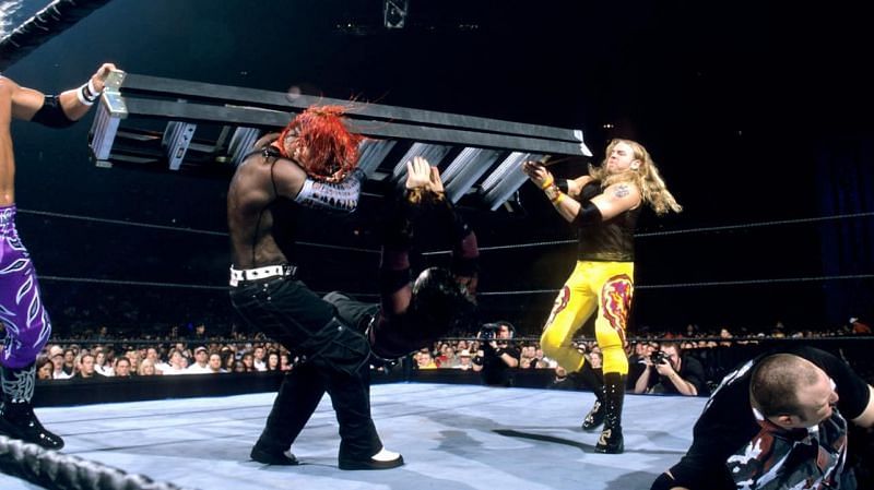 Edge and Christian smash Jeff Hardy with a ladder while Bubba Ray Dudley recovers during the first TLC match.