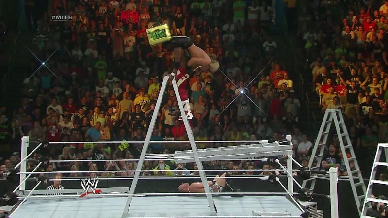 Kofi sends Seth Rollins down onto the unforgiving steel ladder.