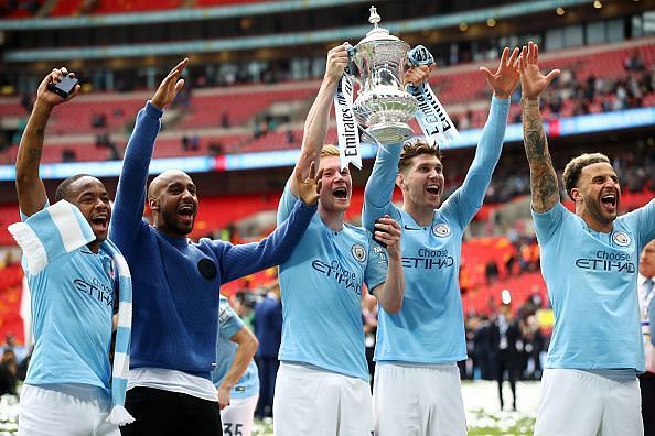 Manchester City players celebrate with the FA Cup trophy aloft after their emphatic win over Watford