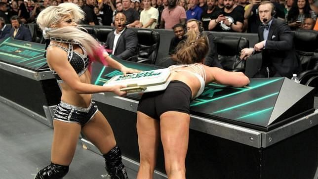 Alexa Bliss bludgeons Ronda Rousey with the Money in the Bank briefcase she had just won.