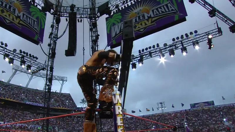 Johnny Impact then known as John Morrison climbs the turnbuckle with a ladder in hand under the open sky