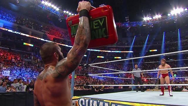 Randy Orton menaces Daniel Bryan--who had just captured the WWE Championship--with the Money in the Bank Briefcase.