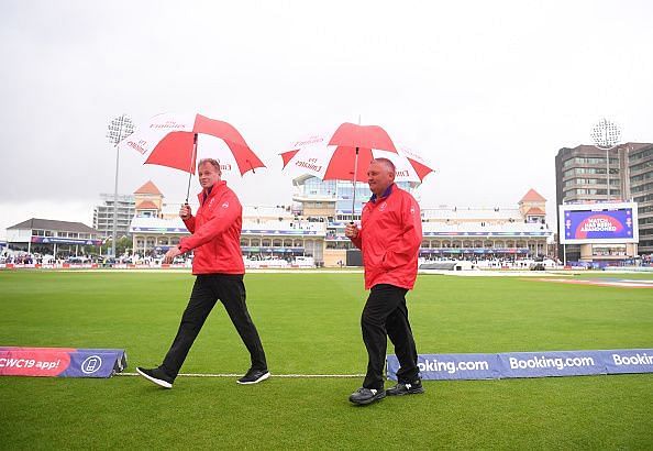 Umpires Paul Reifel and Marais Erasmus take cover under umbrellas in a gloomy Trent Bridge stadium on Thursday.