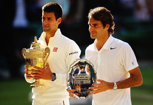 Federer poses with the runner-up trophy following a five-set loss to Djokovic in the 2014 Wimbledon final