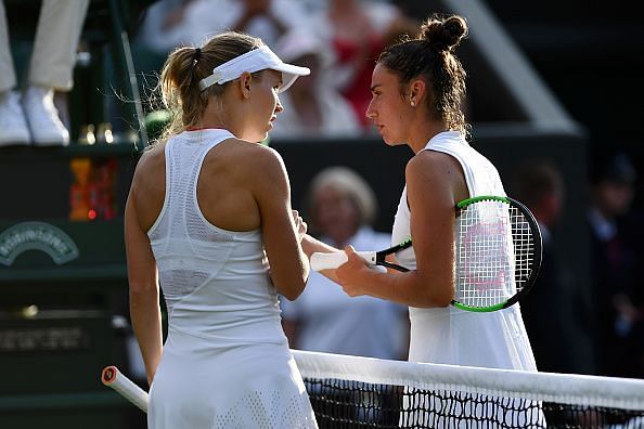 Caroline Wozniacki shakes hands with Sara Sorribes Tormo after she retired from play on Day One at the Championships Wimbledon