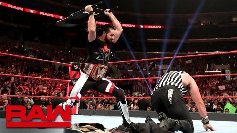 Seth Rollins smashes Elias with a steel chair, not stopping because of a referee shirt.
