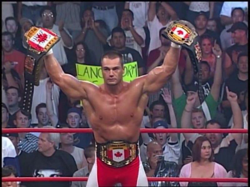 Storm holds all 3 of his WCW title belts - all with Canadian plates on top of them. One is around his waist and the other two in his hands as he leans on the ropes.