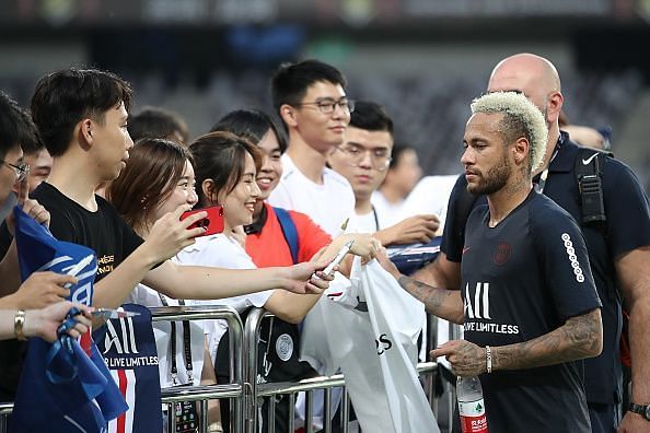Neymar signs autographs.
