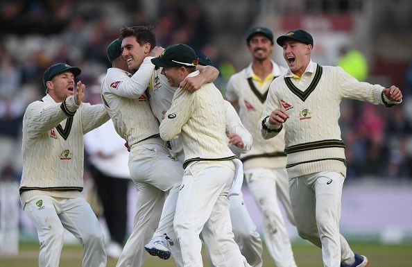 Team-mates swarm around Cummins after Root&#039;s dismissal.