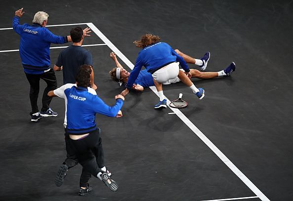 An ecstatic Team Europe joins Zverev on the court after the young German beat Raonic