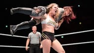 Former RAW Women's Champion Ronda Rousey hoisting Ruby Riott