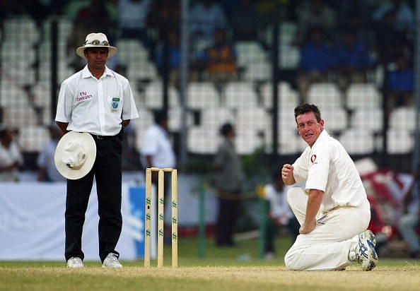 Ashley Giles of England on his knees with Aleem Dar watching