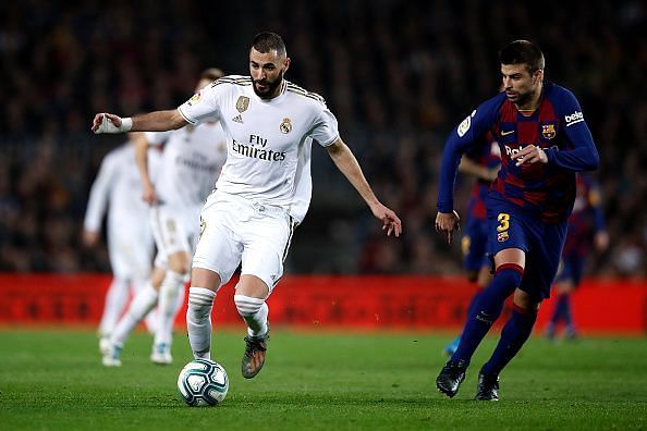 Karim Benzema tries to dribble his way past the Barca defence