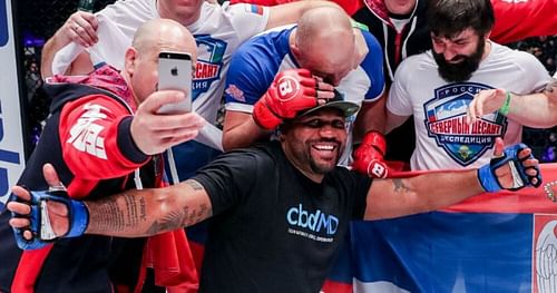 Quinton Jackson posing for photos with Emelianenko's team after the fight.