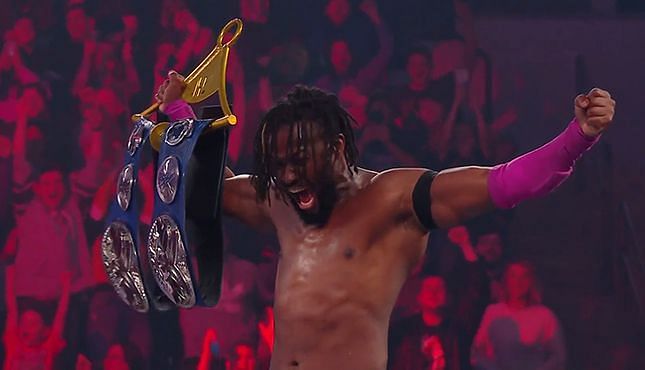 Kofi Kingston holds the SmackDown Tag Team Championship belts
