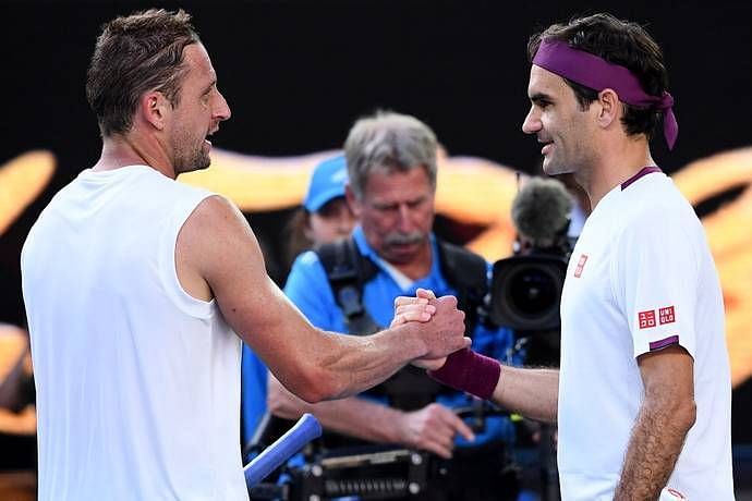 Federer greets Sandgren at the net after their quarterfinal at the 2020 Australian Open