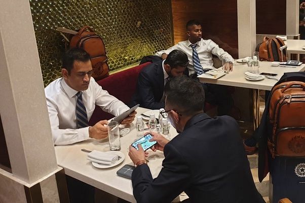 MS Dhoni (left) and Yuzvendra Chahal (second left) playing PUBG Mobile on their smartphones.