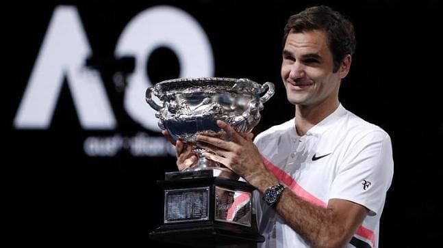 Roger Federer hoists aloft the 2018 Australian Open title