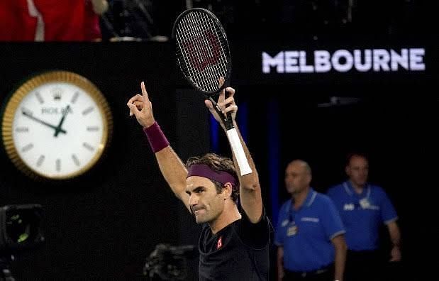 Federer raises his arms in delight after defeating Millman in the third round.