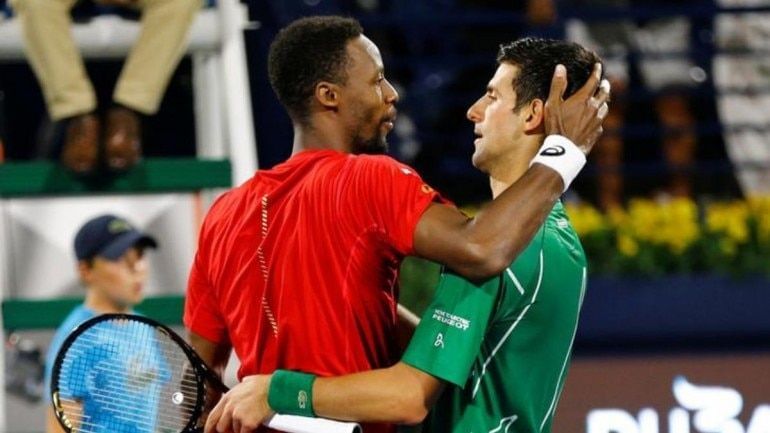 Monfils (right) greets Djokovic at the net following their semifinal