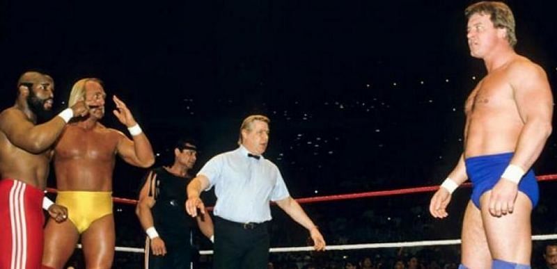 Hulk Hogan, flanked by 1980s film star and cult of personality Mr. T, faces off against Rowdy Roddy Piper at the first Wrestlemania.