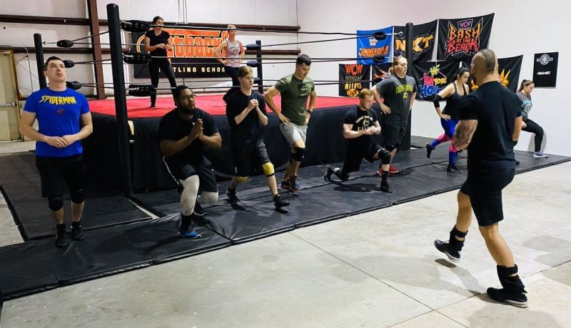 Shawn Spears taking a class through warm-up stretches at his wrestling school.